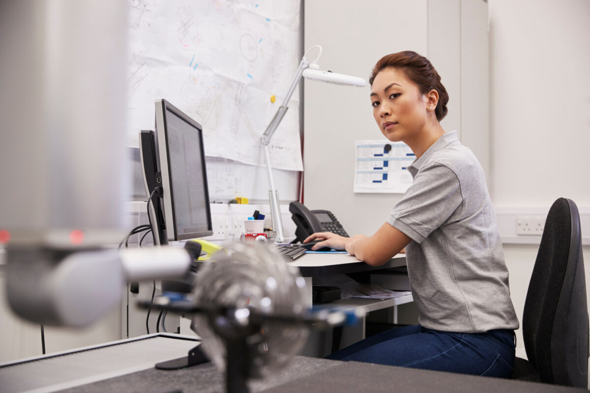 Une ingénieure utilise une machine à mesurer tridimensionnelle dans une usine